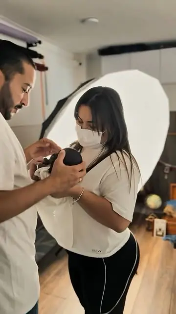 Fotógrafo y asistente del estudio revisando la cámara junto a la luz de estudio